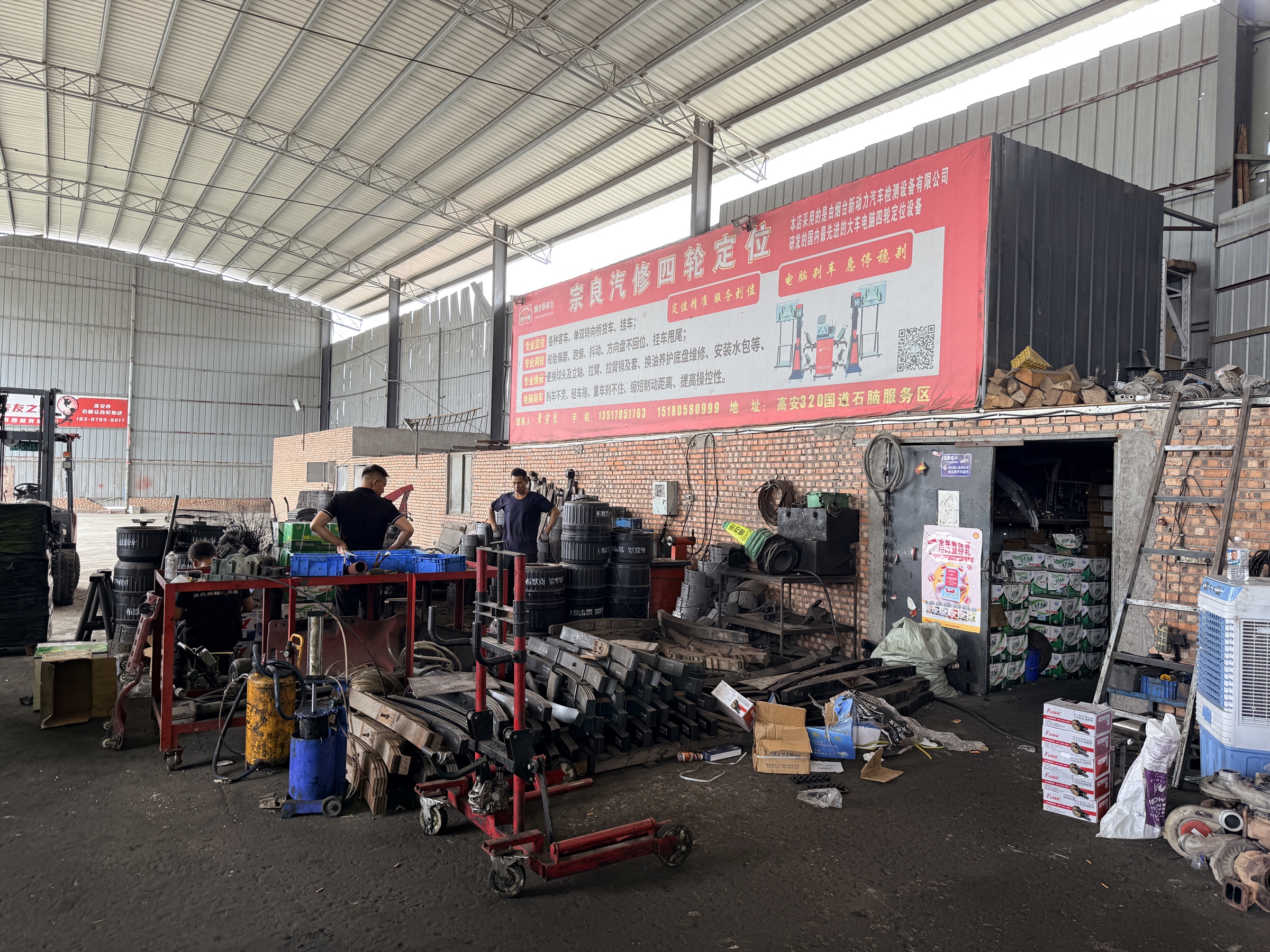 Technicians working with commercial vehicle components in a repair workshop